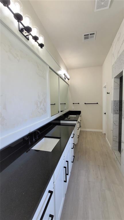 1425 W Harvard Way, Mustang, OK 73064 - full bath with double vanity, wood finished floors, baseboards, and a shower