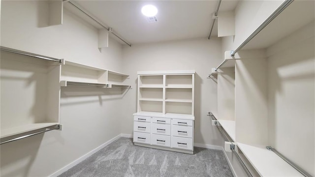 walk in closet featuring light colored carpet