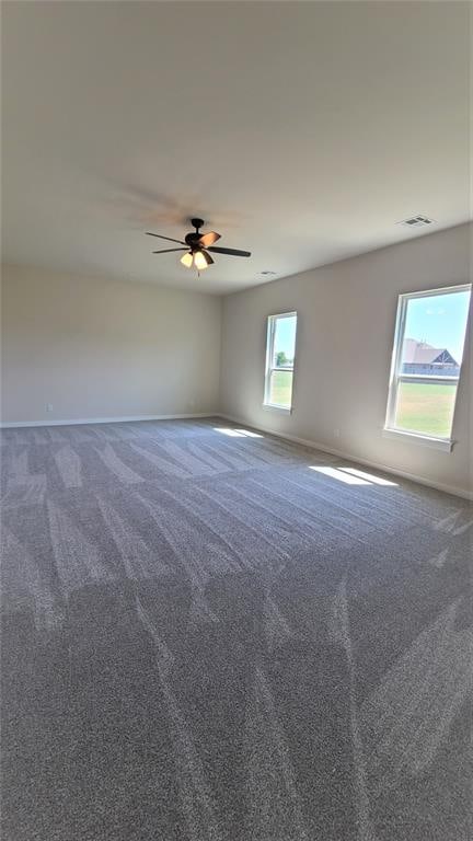 empty room featuring carpet flooring, plenty of natural light, and ceiling fan