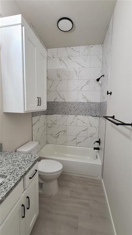 full bathroom with hardwood / wood-style flooring, toilet, vanity, and tiled shower / bath