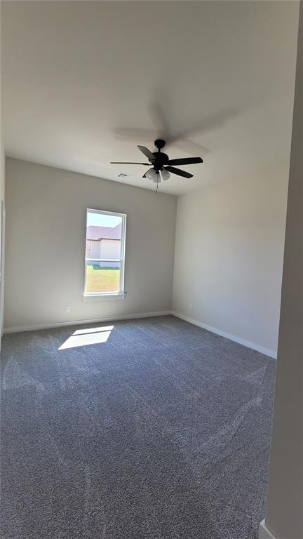 carpeted spare room with ceiling fan