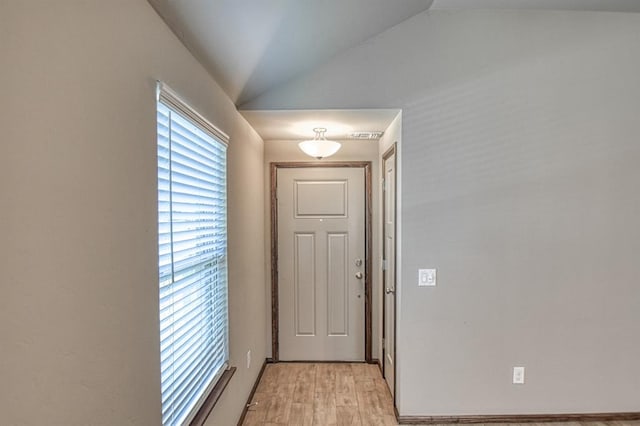 doorway featuring light hardwood / wood-style floors and vaulted ceiling