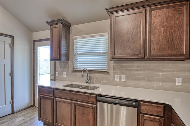 kitchen with dishwasher, sink, tasteful backsplash, vaulted ceiling, and light wood-type flooring