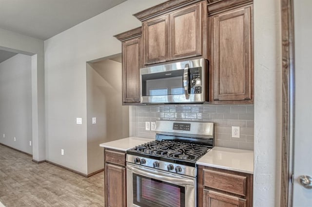 kitchen with backsplash and appliances with stainless steel finishes