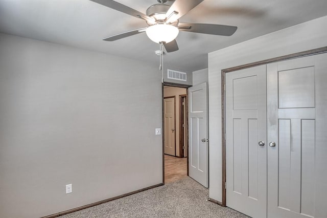 unfurnished bedroom with light colored carpet, a closet, and ceiling fan