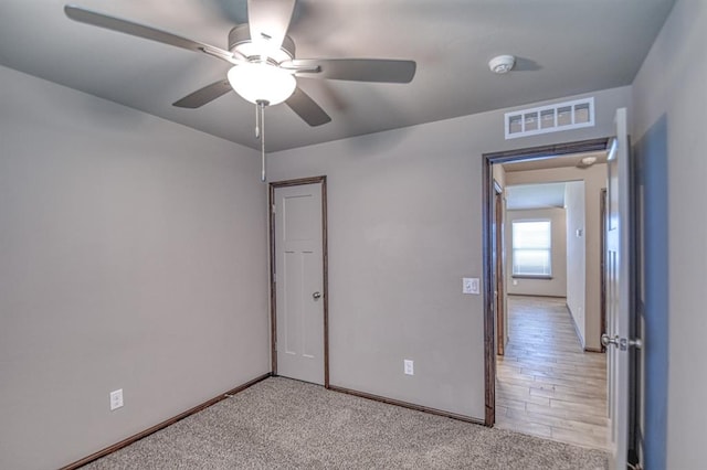 carpeted spare room featuring ceiling fan