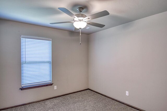 carpeted spare room featuring ceiling fan