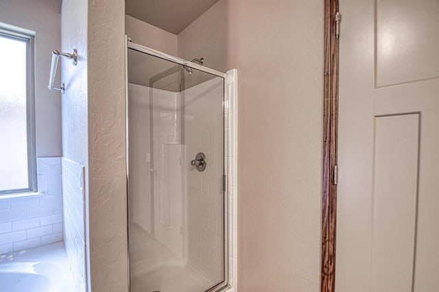 bathroom featuring a shower with door