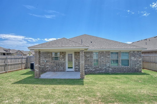 rear view of house featuring cooling unit, a yard, and a patio