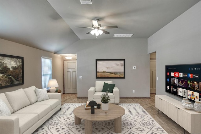 living room with light wood-type flooring, vaulted ceiling, and ceiling fan