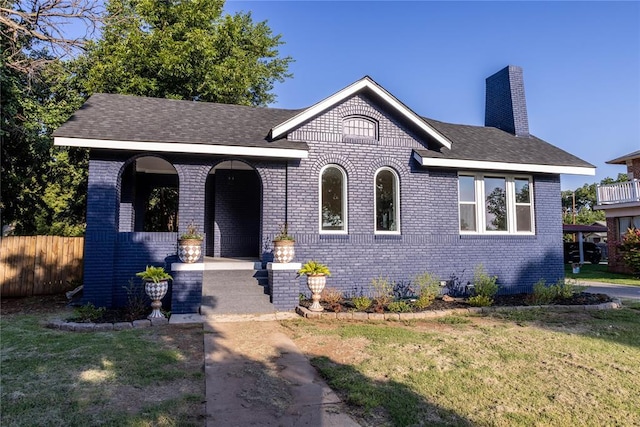 512 N College St, Cordell, OK 73632 - view of front of house with brick siding, a chimney, covered porch, and roof with shingles