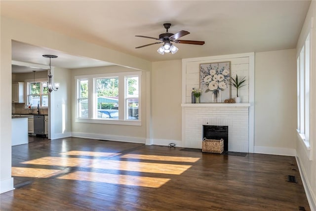 512 N College St, Cordell, OK 73632 - unfurnished living room featuring dark wood-style floors, a fireplace, baseboards, and a ceiling fan
