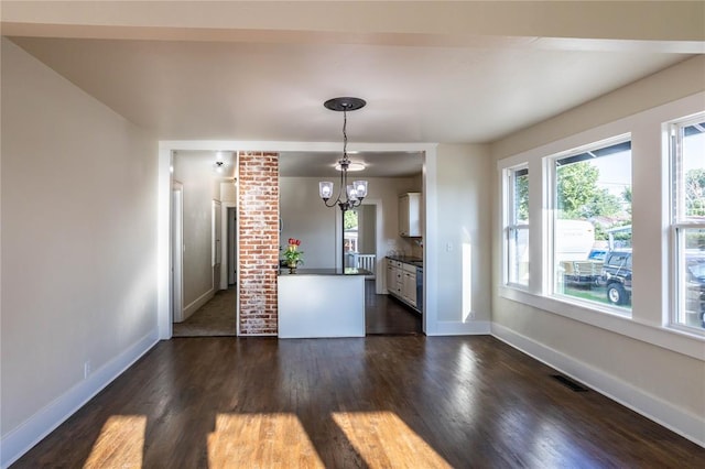 kitchen featuring an inviting chandelier, white cabinetry, hanging light fixtures, and dark wood-type flooring