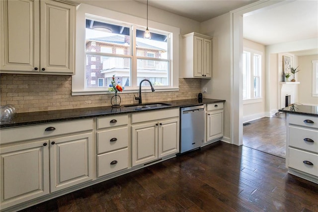 kitchen with dishwasher, sink, dark hardwood / wood-style floors, decorative light fixtures, and decorative backsplash