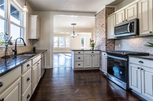 512 N College St, Cordell, OK 73632 - kitchen with stainless steel appliances, a chandelier, a sink, a peninsula, and pendant lighting