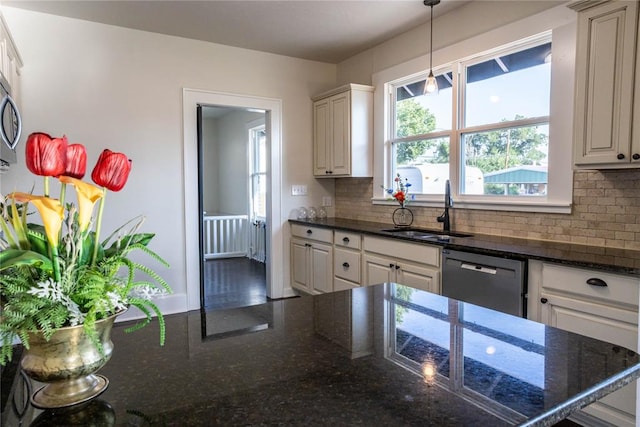 kitchen featuring stainless steel dishwasher, dark stone countertops, white cabinets, and sink