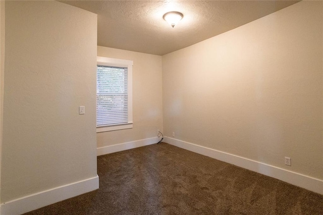 carpeted empty room with a textured ceiling