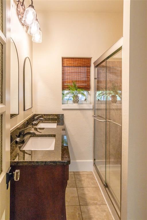 bathroom featuring tile patterned flooring, vanity, and a shower with door