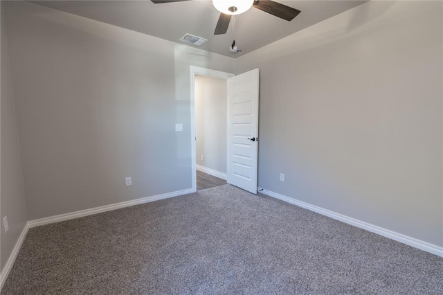 unfurnished room with ceiling fan and dark carpet