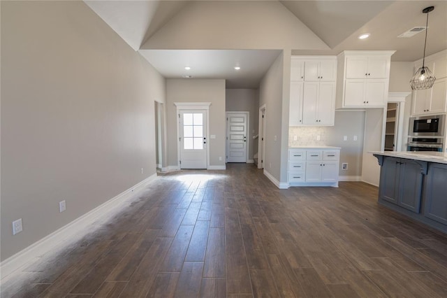 kitchen with hanging light fixtures, white cabinets, backsplash, and dark hardwood / wood-style floors