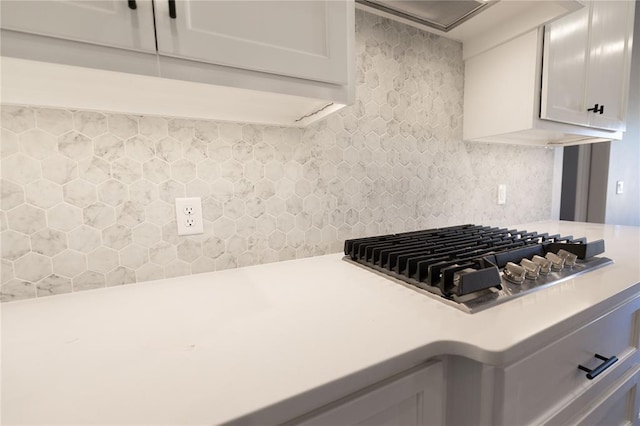 kitchen with backsplash, white cabinets, and stainless steel gas cooktop