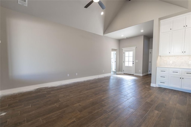 unfurnished living room with high vaulted ceiling, dark hardwood / wood-style floors, beam ceiling, and ceiling fan