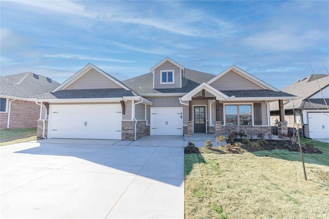 craftsman-style house featuring a front yard, an attached garage, concrete driveway, and roof with shingles