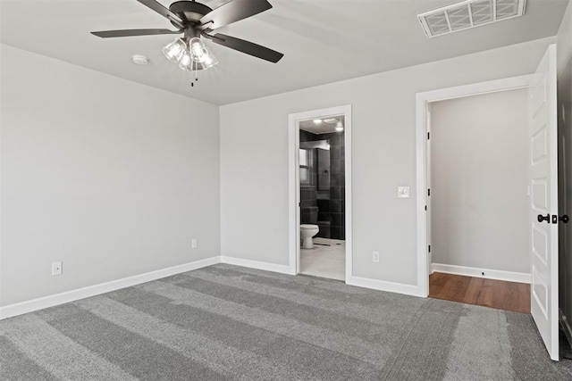 unfurnished bedroom with ceiling fan, carpet, and ensuite bathroom