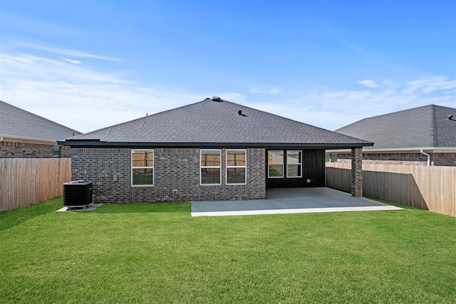 rear view of property with a lawn, central air condition unit, and a patio