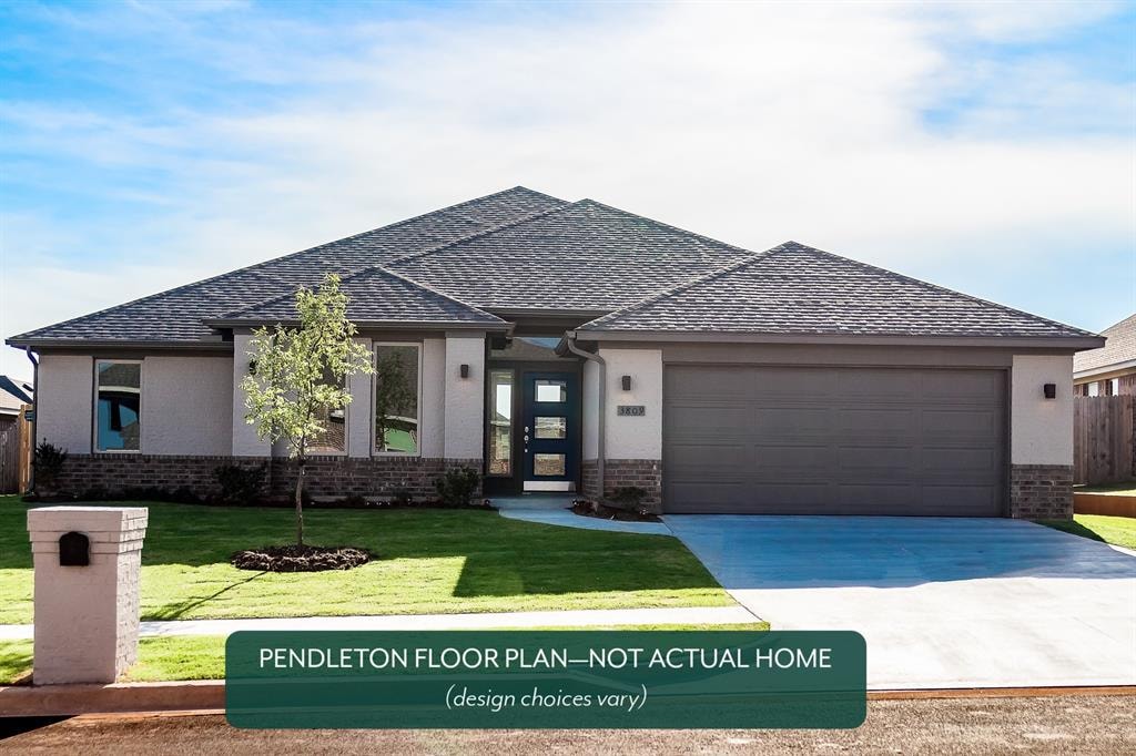 view of front of house featuring a garage and a front lawn