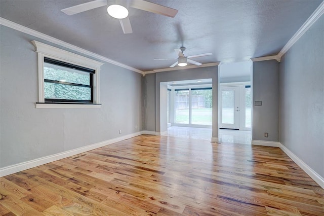 empty room featuring plenty of natural light, light hardwood / wood-style floors, and ornamental molding