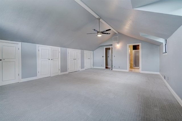 additional living space featuring ceiling fan, light colored carpet, and lofted ceiling