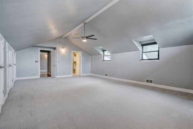 additional living space featuring ceiling fan, light colored carpet, and vaulted ceiling