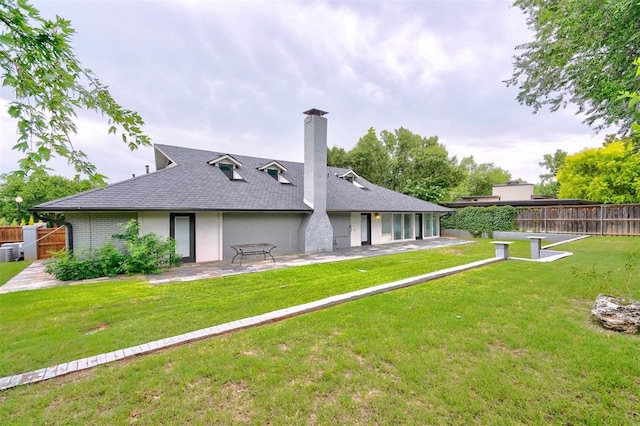 back of property featuring a yard, central AC unit, and a patio area