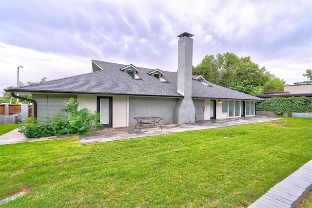 rear view of property with a yard and a patio