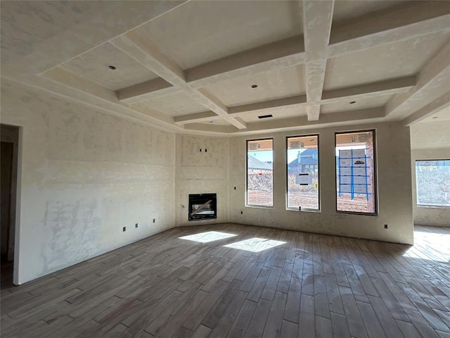 unfurnished living room featuring hardwood / wood-style flooring, coffered ceiling, and beamed ceiling