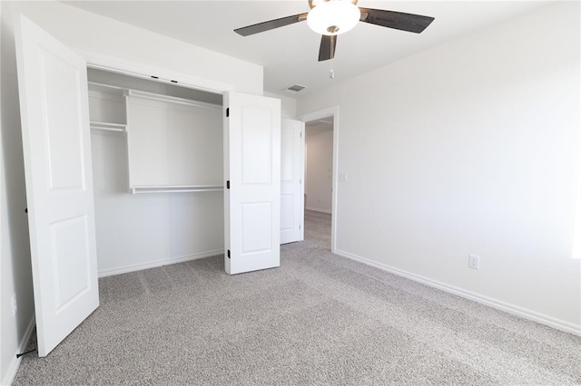 unfurnished bedroom with light colored carpet, a closet, and ceiling fan