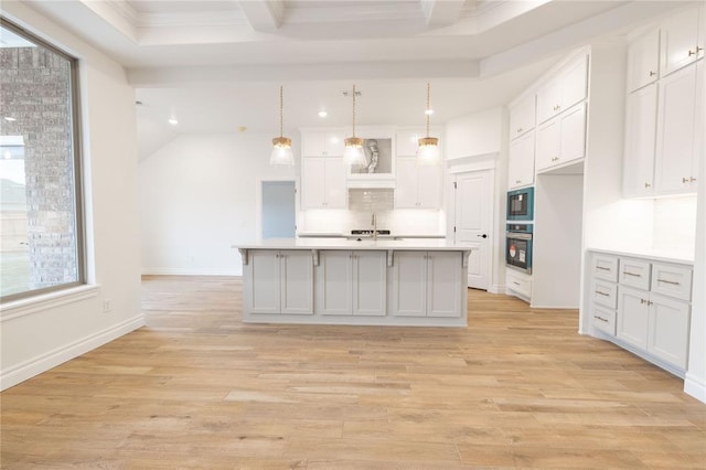 kitchen featuring light wood-type flooring, white cabinets, light countertops, and stainless steel oven