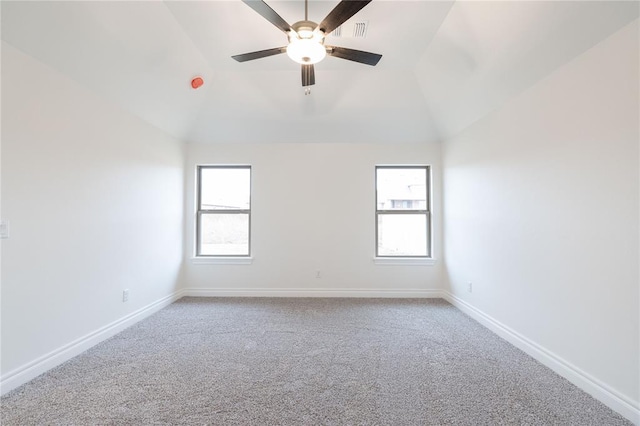 carpeted empty room featuring lofted ceiling, a wealth of natural light, and baseboards