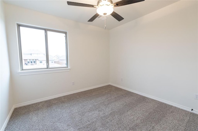 empty room with ceiling fan, carpet floors, and baseboards