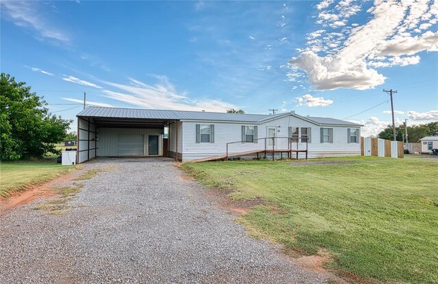306 E Ninth St, Leedey, OK 73654 - manufactured / mobile home with gravel driveway, a front yard, and a garage