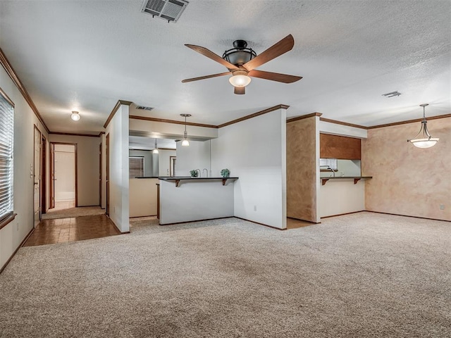 unfurnished living room with light carpet, a textured ceiling, ceiling fan, and crown molding