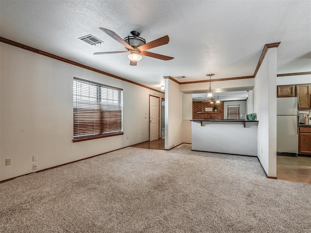 unfurnished living room with ceiling fan, light carpet, and a textured ceiling