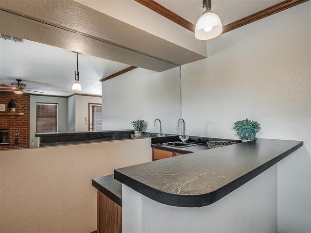 kitchen with sink, crown molding, hanging light fixtures, ceiling fan, and kitchen peninsula