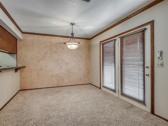 unfurnished dining area with a textured ceiling, light colored carpet, and crown molding