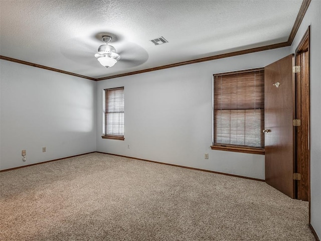 carpeted spare room with ceiling fan, a textured ceiling, and ornamental molding