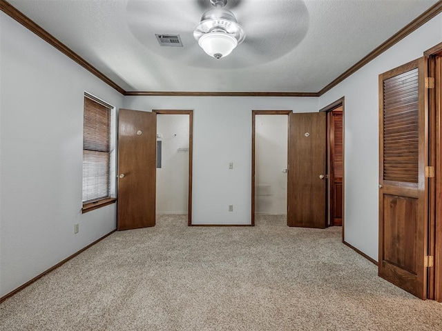 unfurnished bedroom featuring a textured ceiling, light colored carpet, ceiling fan, and ornamental molding