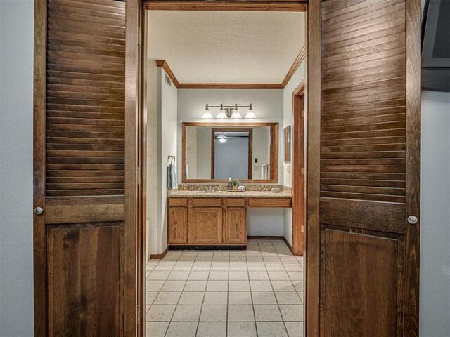 bathroom featuring tile patterned flooring, vanity, and crown molding