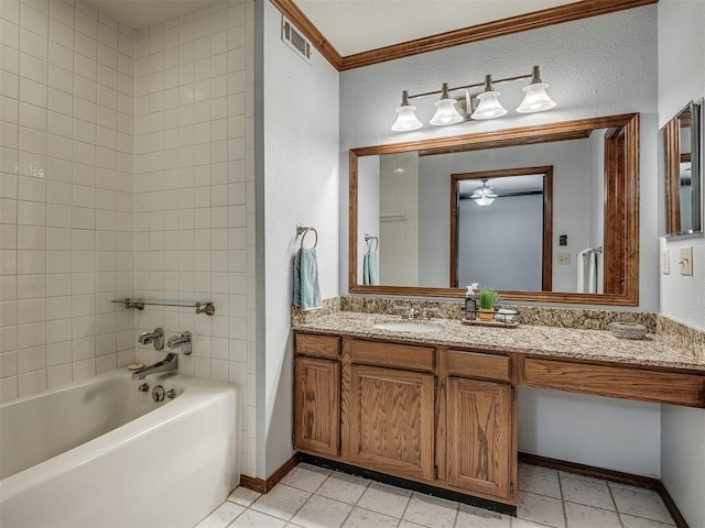 bathroom featuring tile patterned flooring, vanity, tiled shower / bath, and crown molding