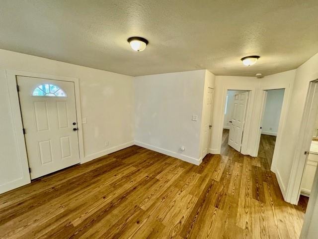 foyer with wood-type flooring and a textured ceiling